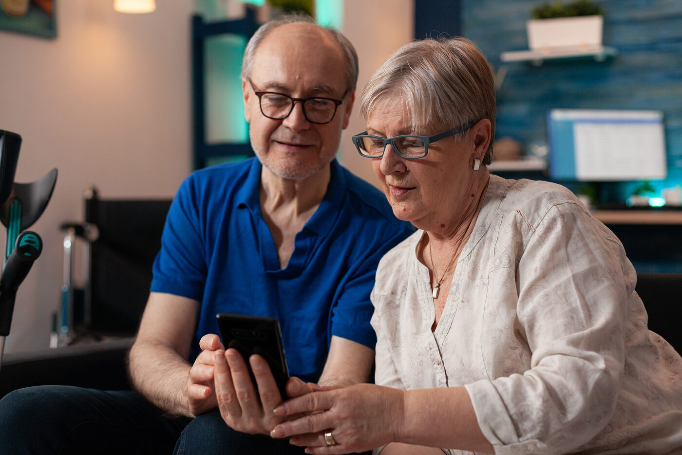 An older couple looking at church content on a phone together